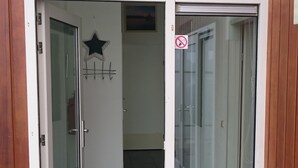 A hallway with a star decoration, a no-smoking sign, and a door leading to a room with a window. - House by Uitgeestermeer With Garden (Uitgeest)