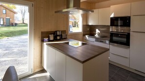A modern kitchen with a central island, stainless steel appliances, and wooden cabinetry. - Chalet With Indoor hot tub (Sankt Georgen am Kreischberg)