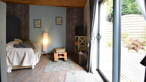 Een slaapkamer met een bed, een lamp, een houten kast en een rieten mand.