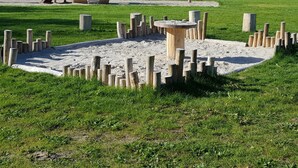 A playground with a wooden slide and climbing structures. - Tidy Chalet with Microwave near Wadden Sea (Tzummarum)