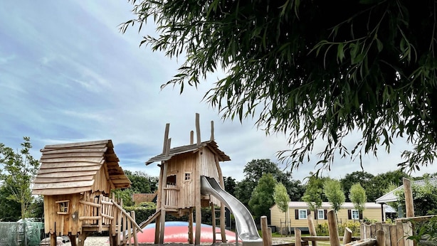 A wooden play structure with a slide and a small house. - Modern Dutch Villa With Terrace (Hippolytushoef)