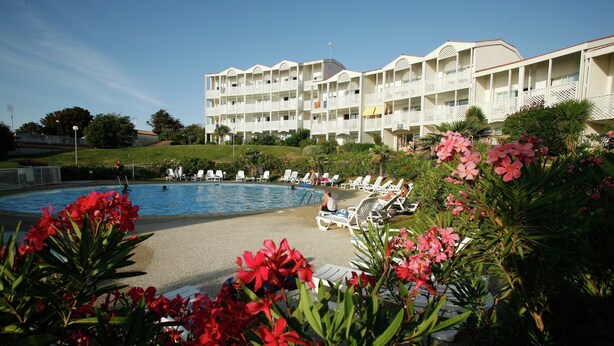A hotel with a swimming pool, lounge chairs, and a landscaped garden. - Apartment in France With Ocean Views (Fouras)