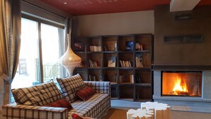 Uma sala de estar com sofá, lareira e estante.