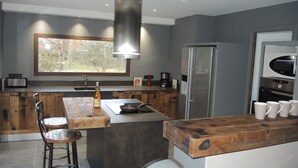 A modern kitchen with a large window, a built-in oven, and a refrigerator. - Holiday Home in L'isle-sur-la-sorgue With Pool (L'Isle-sur-la-Sorgue)