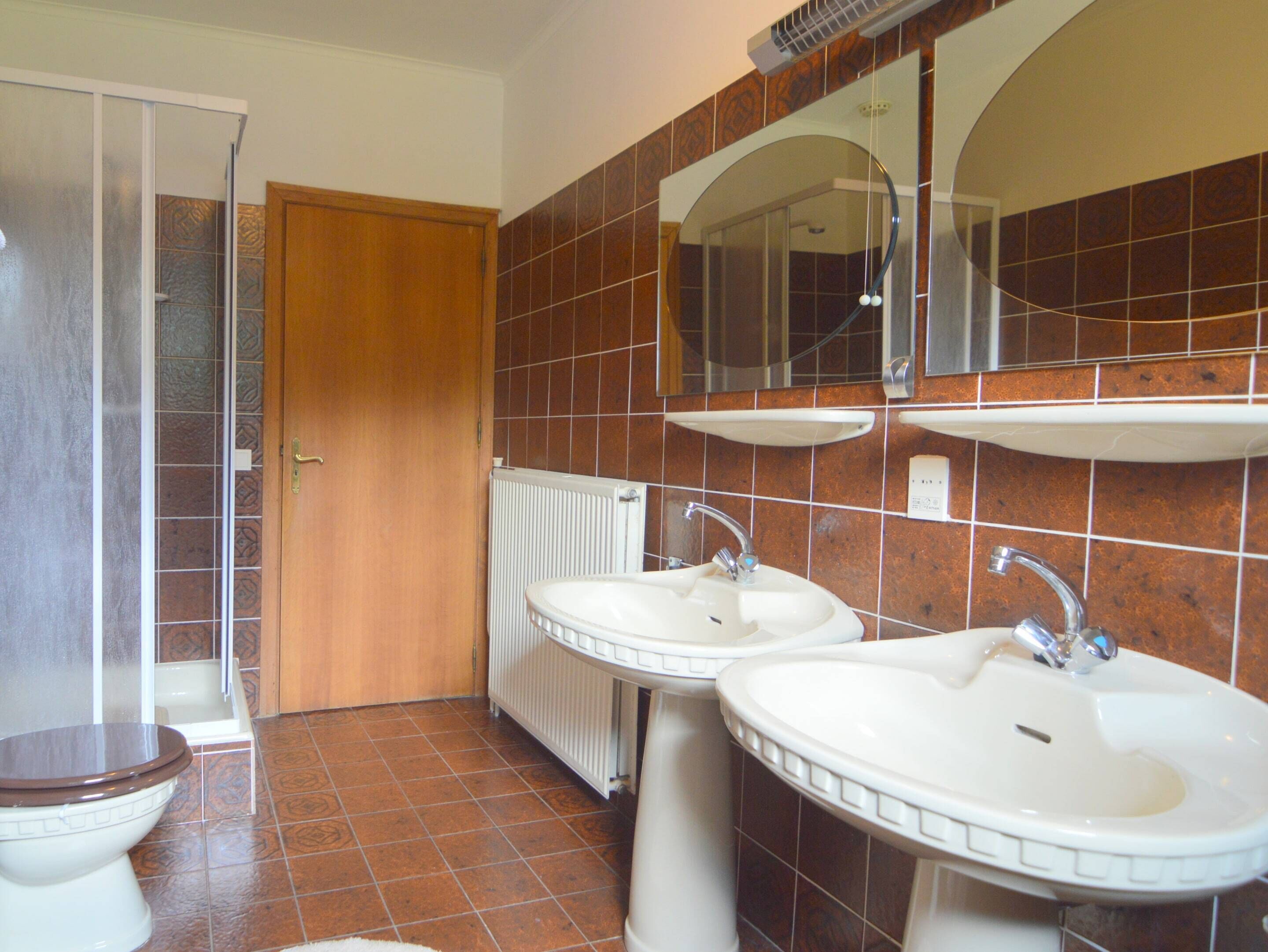 Ein Badezimmer mit zwei Waschbecken, einer Toilette und einer Dusche.
