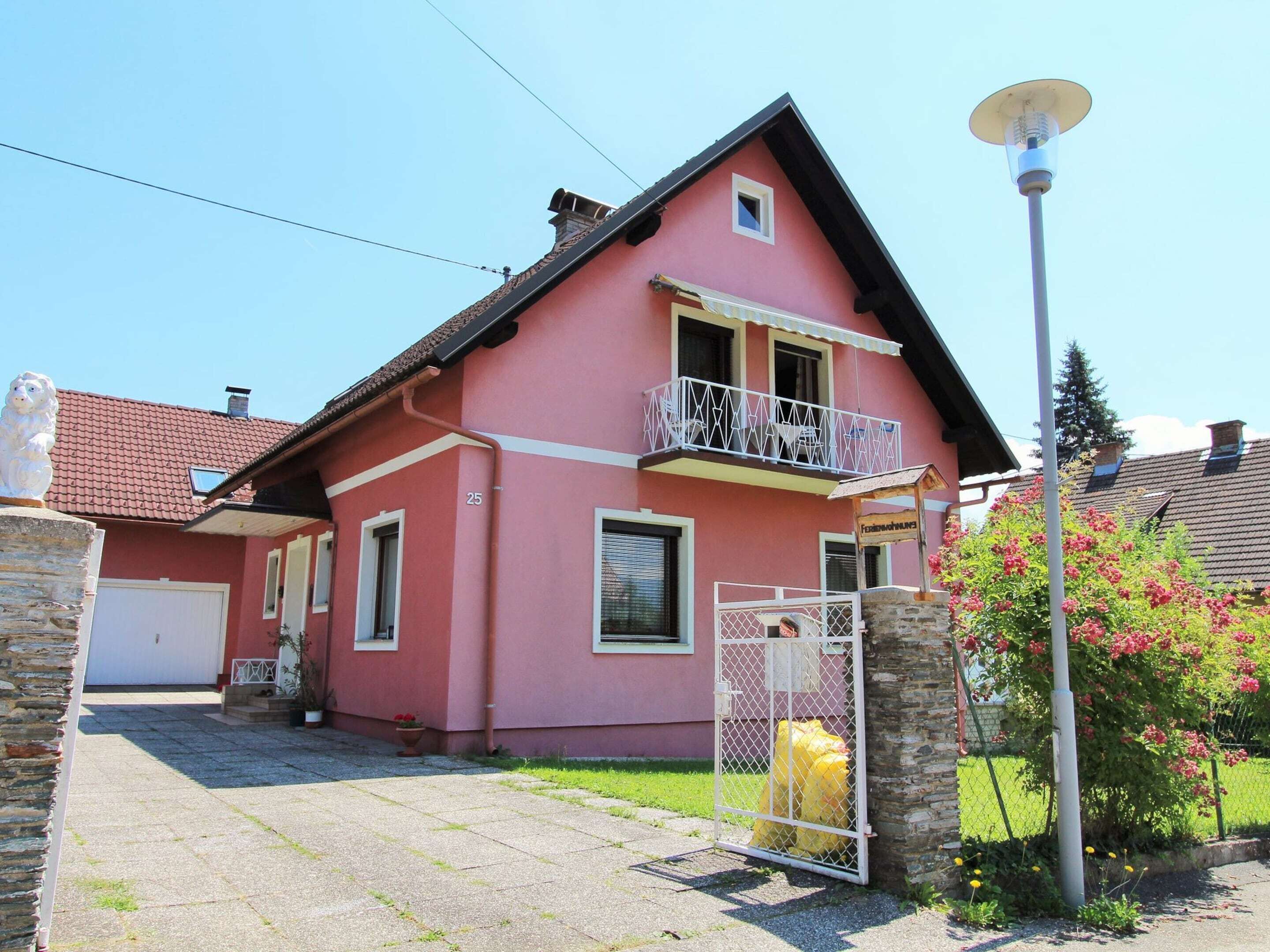 A two-story house with a balcony, a garage, and a fenced yard.