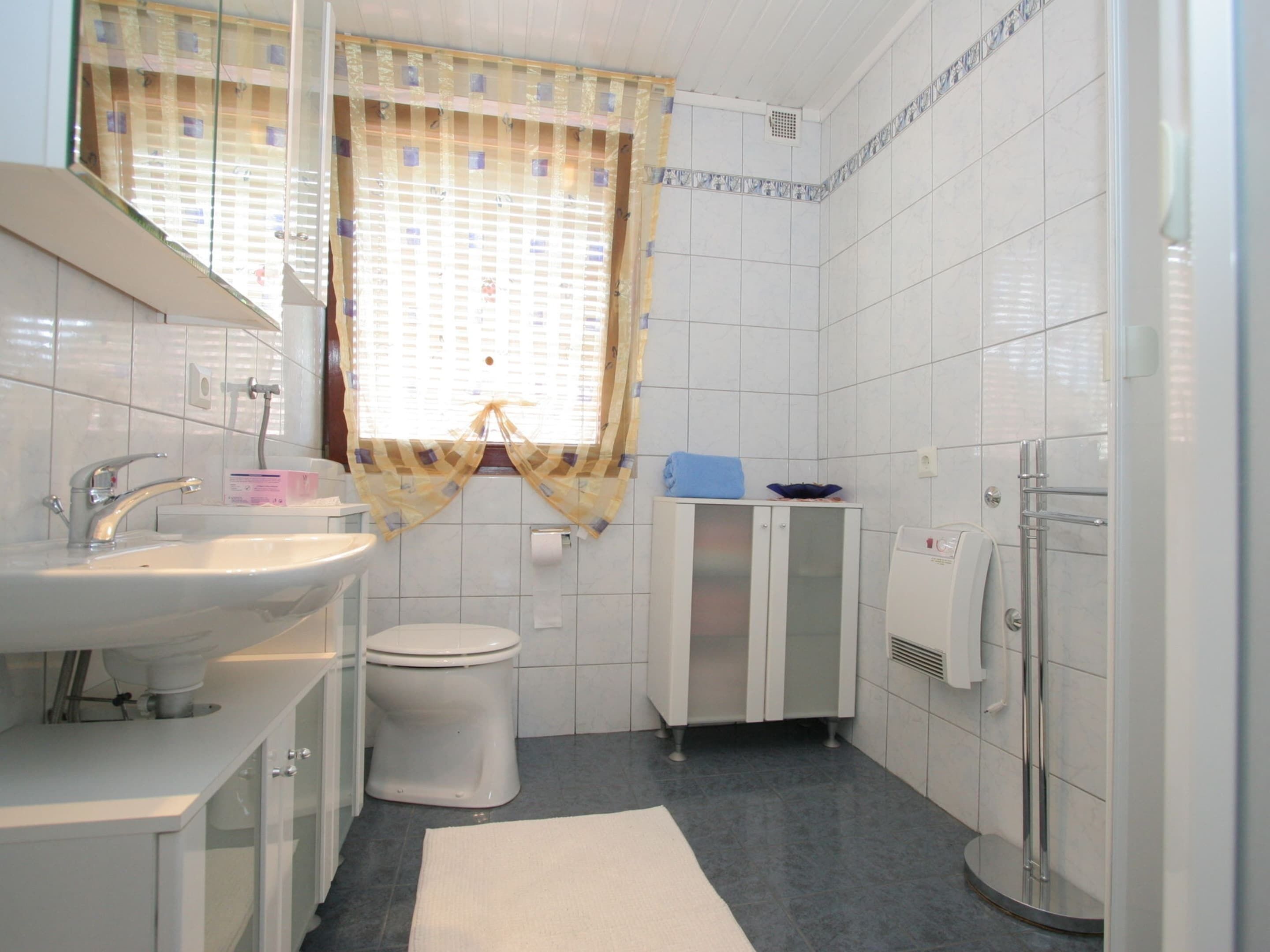 A bathroom with a sink, toilet, and shower.