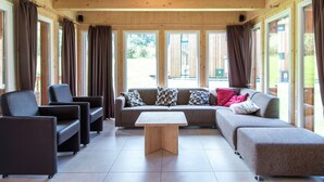 A spacious living area with a sofa set, a coffee table, and a fireplace. - Spectacular Chalet near Ski Area in Sankt Georgen ob Murau (Sankt Georgen am Kreischberg)