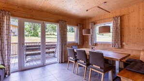 Un interior de madera con una mesa de comedor, sillas y un banco.