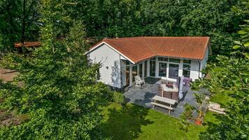 Escape to a serene retreat surrounded by lush greenery, with a spacious patio area perfect for dining and relaxation.