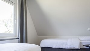 A bedroom with a bed, a bedside table, and a window. - Bungalow on Texel Near De Slufter Reserve (De Cocksdorp)