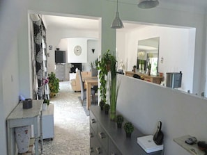 A modern kitchen with a dining area, a large mirror, and potted plants. - Villa in Puget-sur-argens With Pool & Garden (Puget-sur-Argens)