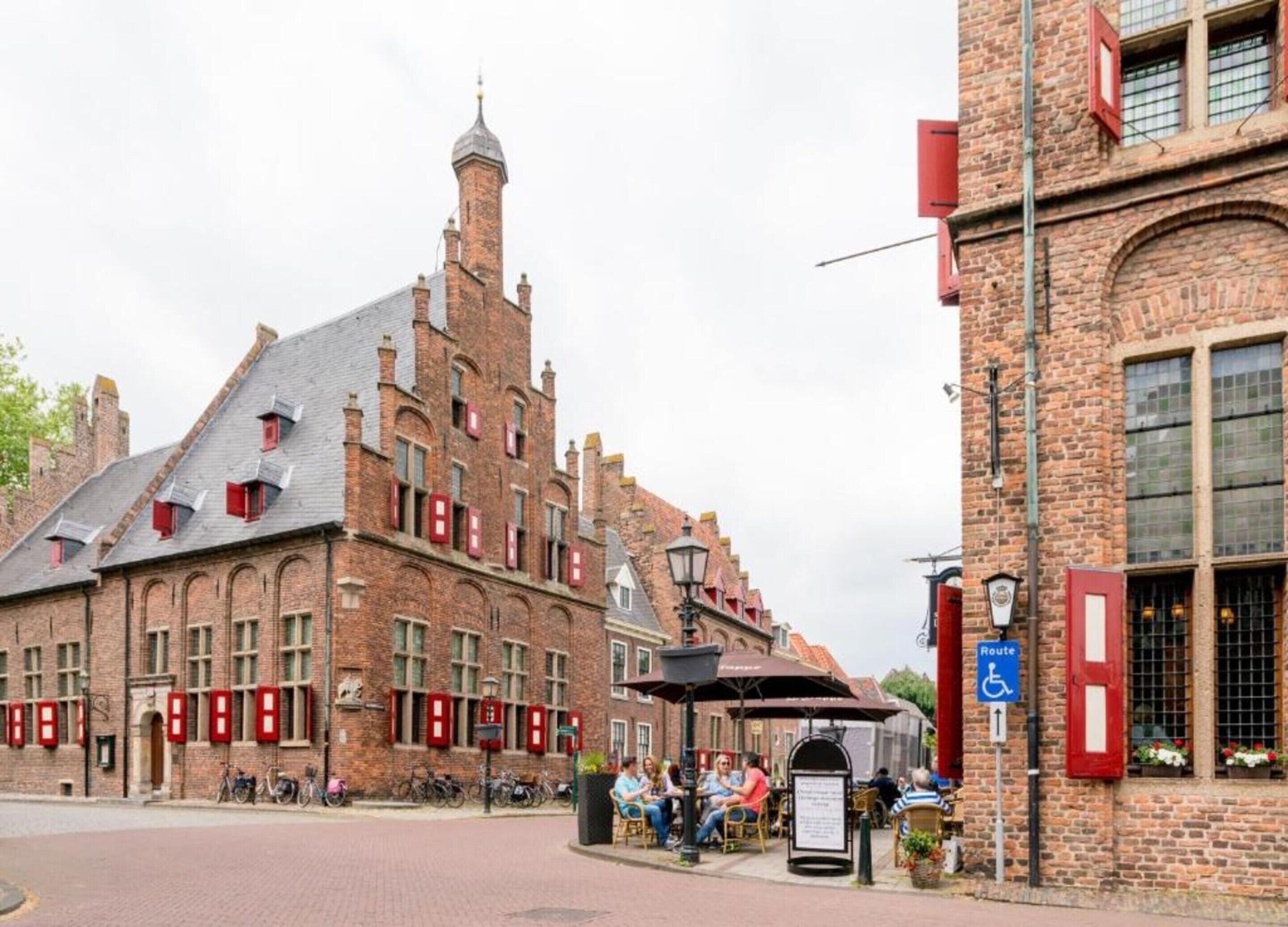 A historic building with a prominent tower and red window shutters.