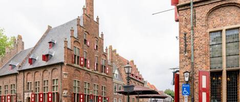 A historic building with a prominent tower and red window shutters.