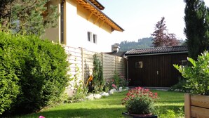 A well-maintained garden with a wooden deck, potted plants, and a small shed. - Plush Apartment in Altenmarkt im Pongau near Ski Area (Altenmarkt im Pongau)