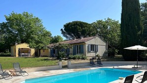 A swimming pool with lounge chairs, a small building with a tiled roof, and surrounding greenery. - Holiday Home in Villecroze With Pool & Garden (Villecroze)