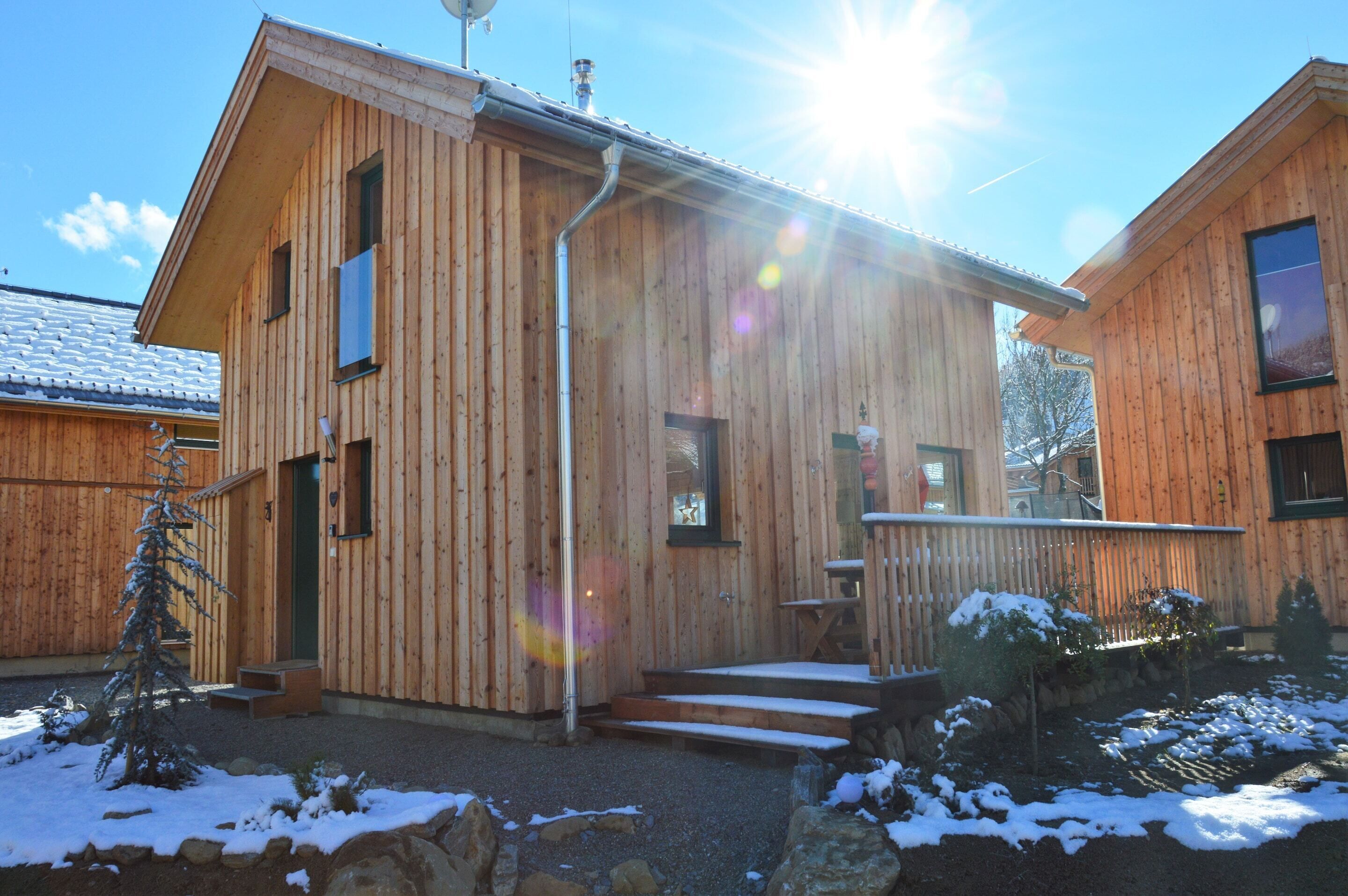 A wooden cabin with a porch and steps leading to the entrance.