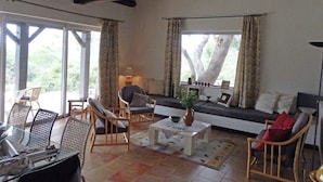 Ein geräumiges Wohnzimmer mit großem Fenster, einer Sofagarnitur und einem Essbereich mit Stühlen und Tisch.