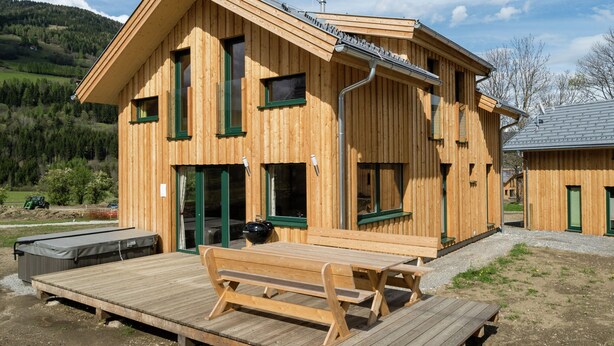 A wooden cabin with a deck and picnic table, surrounded by a natural landscape. - Chalet With Whirlpool tub (Sankt Georgen am Kreischberg)