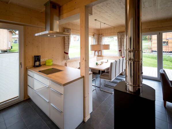 Une cuisine moderne dotée d’un îlot central, d’une cuisinière et d’un coin repas avec une table et des chaises.