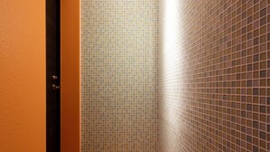 A narrow hallway with a tiled wall and a carpeted floor. - Ginza Tsukiji GUEST HOUSE 301. (Chuo)