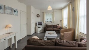 A living room with a sofa, a coffee table, a television, and a lamp. - From the Zealand Coast and Near Brugge (Aardenburg)