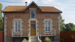 A two-story brick house with a tiled roof, a front door, and a small front porch with steps. - Horville Garden Retreat (Gondrecourt-le-Château)