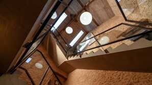 A multi-level interior with exposed brick walls, a staircase with glass railings, and pendant lighting. - Retreat Near Siorac-en-perigord (Saint-Germain-de-Belvès)