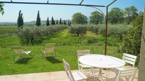 An outdoor patio with a table and chairs, surrounded by a garden and a view of the countryside. - Holiday Home in Beziers With Pool and Vineyard (Murviel-les-Beziers)