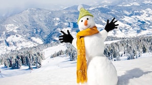 Um boneco de neve com chapéu verde e cachecol amarelo, em uma paisagem nevada com montanhas ao fundo.