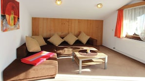 A cozy living room with a brown sofa, a wooden coffee table, and a painting on the wall. - Splendid Apartment in Fugen near Ski Area (Fuegen)