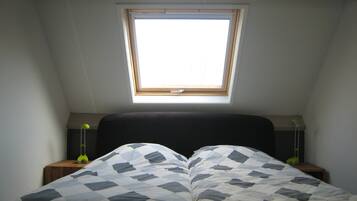 Une chambre à coucher avec un lit, une fenêtre et deux lampes de chevet.