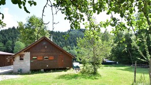 A wooden cabin with a sloped roof, a small porch, and a window with shutters. - Quiet Chalet With Garden (Saint-Quirin)