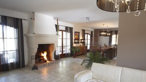 Ein Wohnzimmer mit Kamin, einer Couch und einem Essbereich.