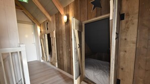 A wooden interior with bunk beds, a white railing, and a wooden floor. - Family Home in Rural Location near Coast of Noord-holland Province (Callantsoog)