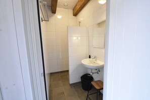 A bathroom with a white sink, a mirror, and a shower area. - Family Home in Rural Location near Coast of Noord-holland Province (Callantsoog)