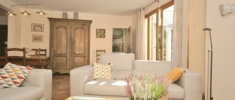 A living room with a sofa, a coffee table, and a potted plant.