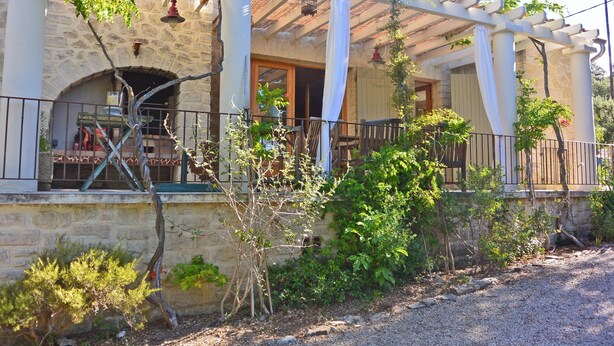 A stone building with a covered porch, a wooden fence, and a gravel path. - Villa in Crillon-le-brave Near Mont Ventoux (Crillon-le-Brave)