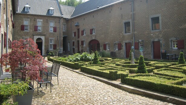A courtyard with a cobblestone path, benches, and a hedge maze. - Spacious Apartment near Town Center in Mesch (Eijsden)