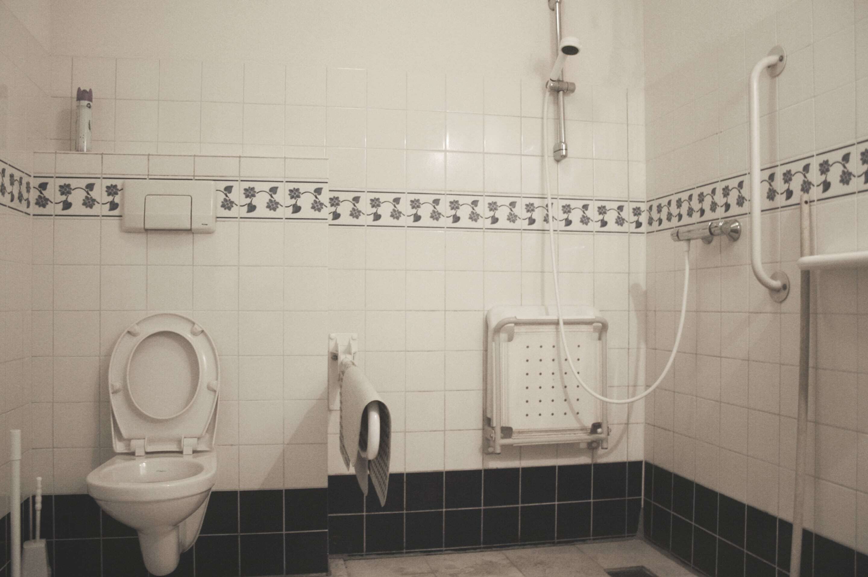 Un baño con inodoro, ducha y secamanos.