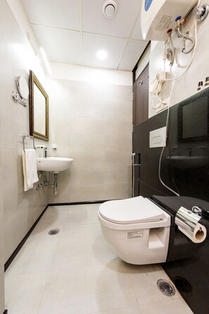 A compact bathroom with a white toilet, a sink, and a mirror. - House of Backpackers (Jaipur)