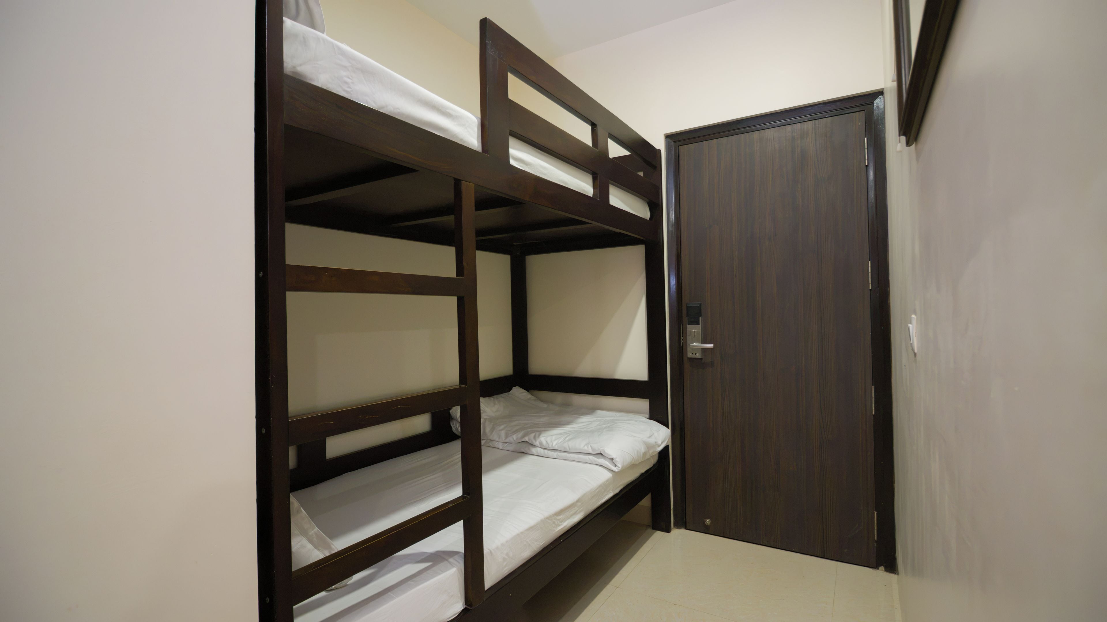 Habitación con literas y puerta de madera.