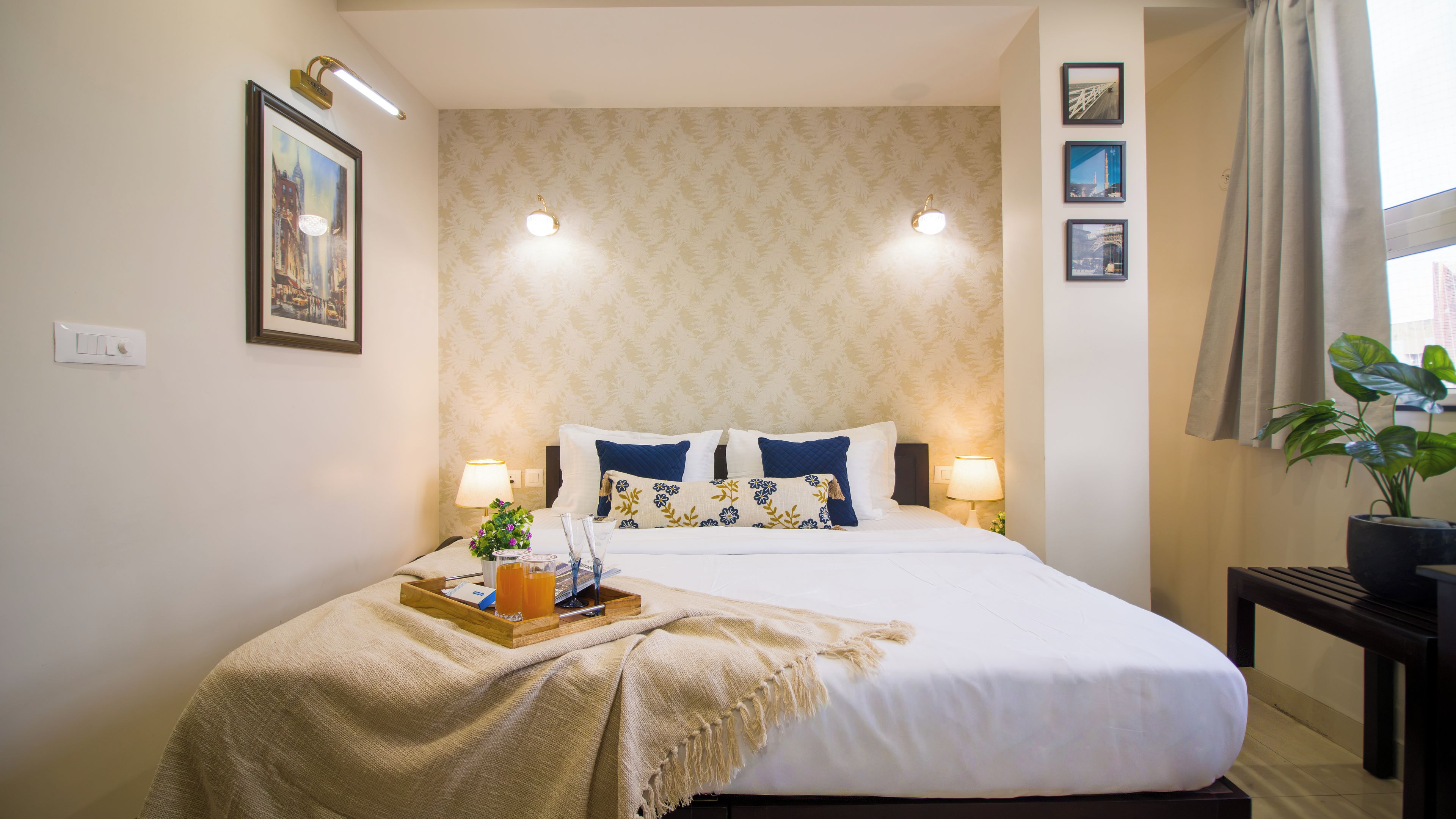 A hotel room with a bed, bedside lamps, a nightstand, a tray with items, and a window with curtains.