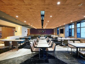 A modern dining area with multiple tables and chairs, a wooden ceiling, and large windows. - Mercure Yinchuan Xinhua (Yinchuan)