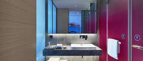 A modern bathroom with a large mirror, a sink, and a towel rack.