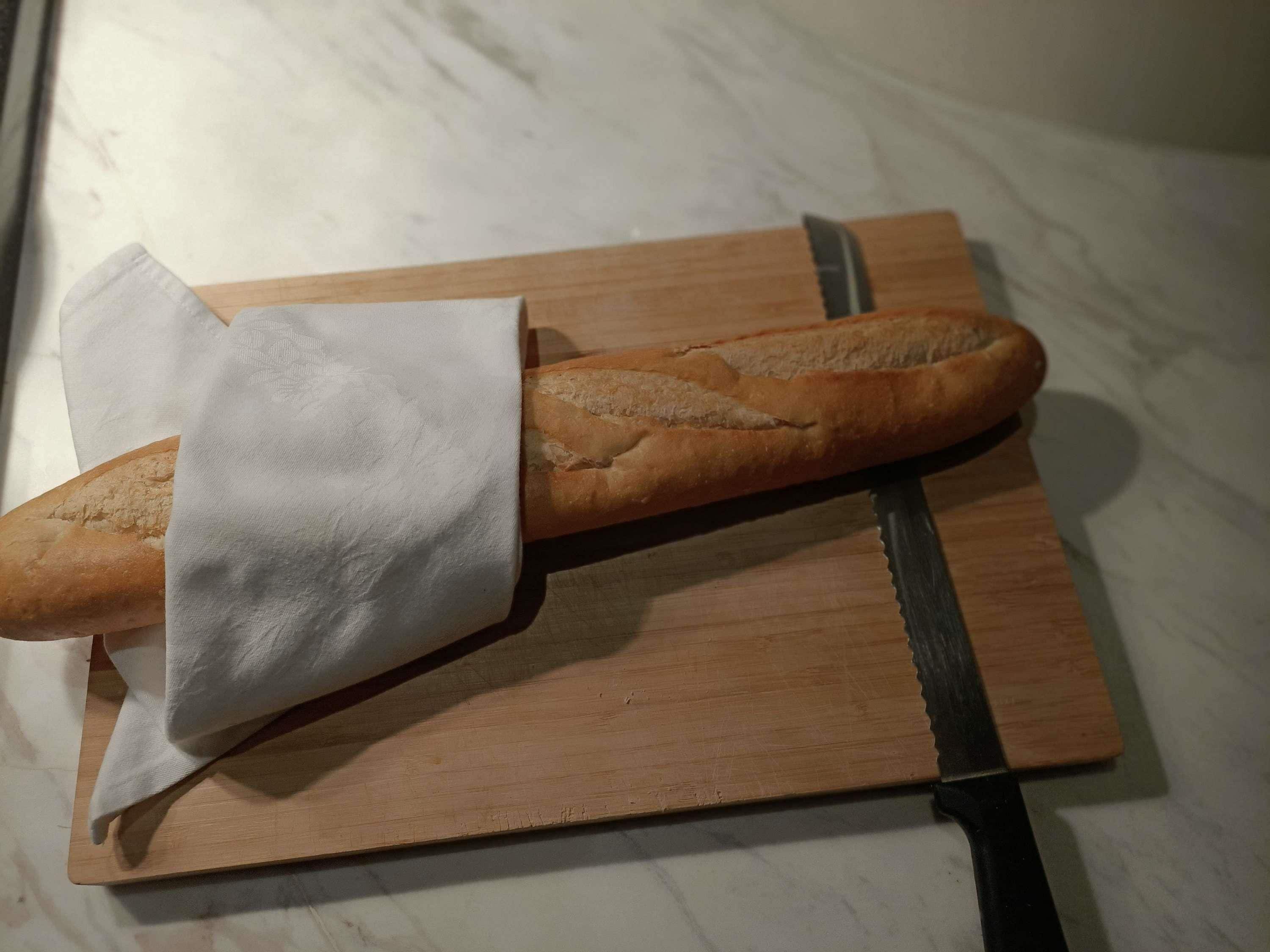 A baguette on a wooden cutting board.
