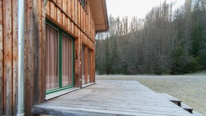 A wooden cabin with a wooden deck and a green door. - Chalet in Stadl an der Mur / Styria With Terrace (Stadl-Predlitz)