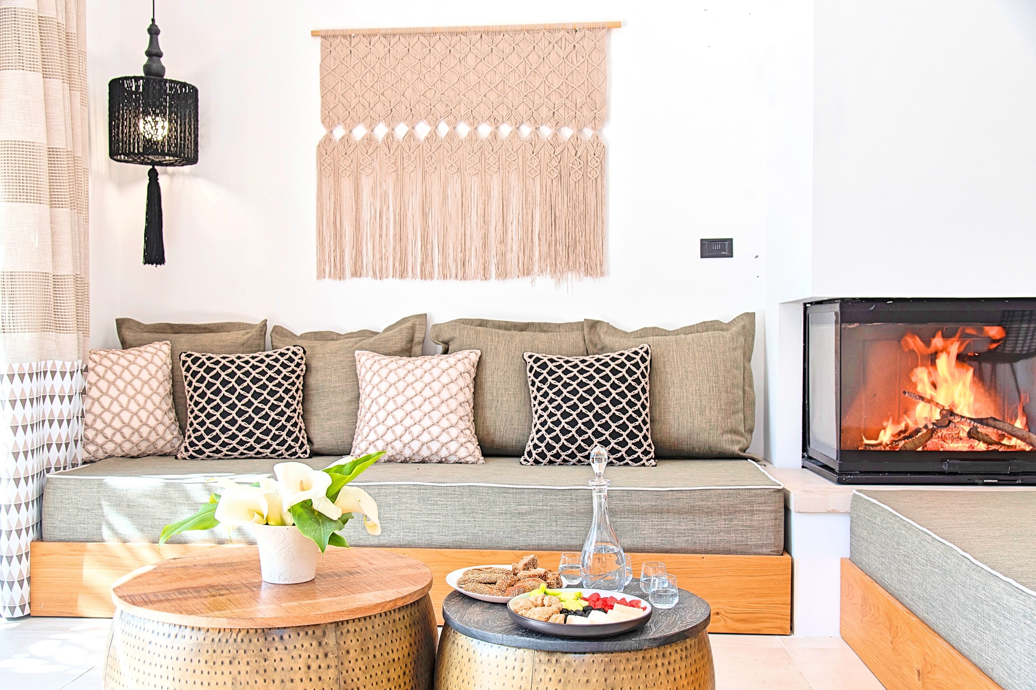 A cozy living room with a sofa, a fireplace, and a coffee table with snacks.