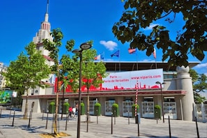 A building with a large red banner advertising Paris expo Porte de Versailles. - Smart Apart in Paris (Vanves)