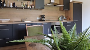 A modern kitchen with wooden cabinets, a stainless steel sink, and a coffee maker. - "All alone" relax without neighbors and other guests   (Sevenig / Our)